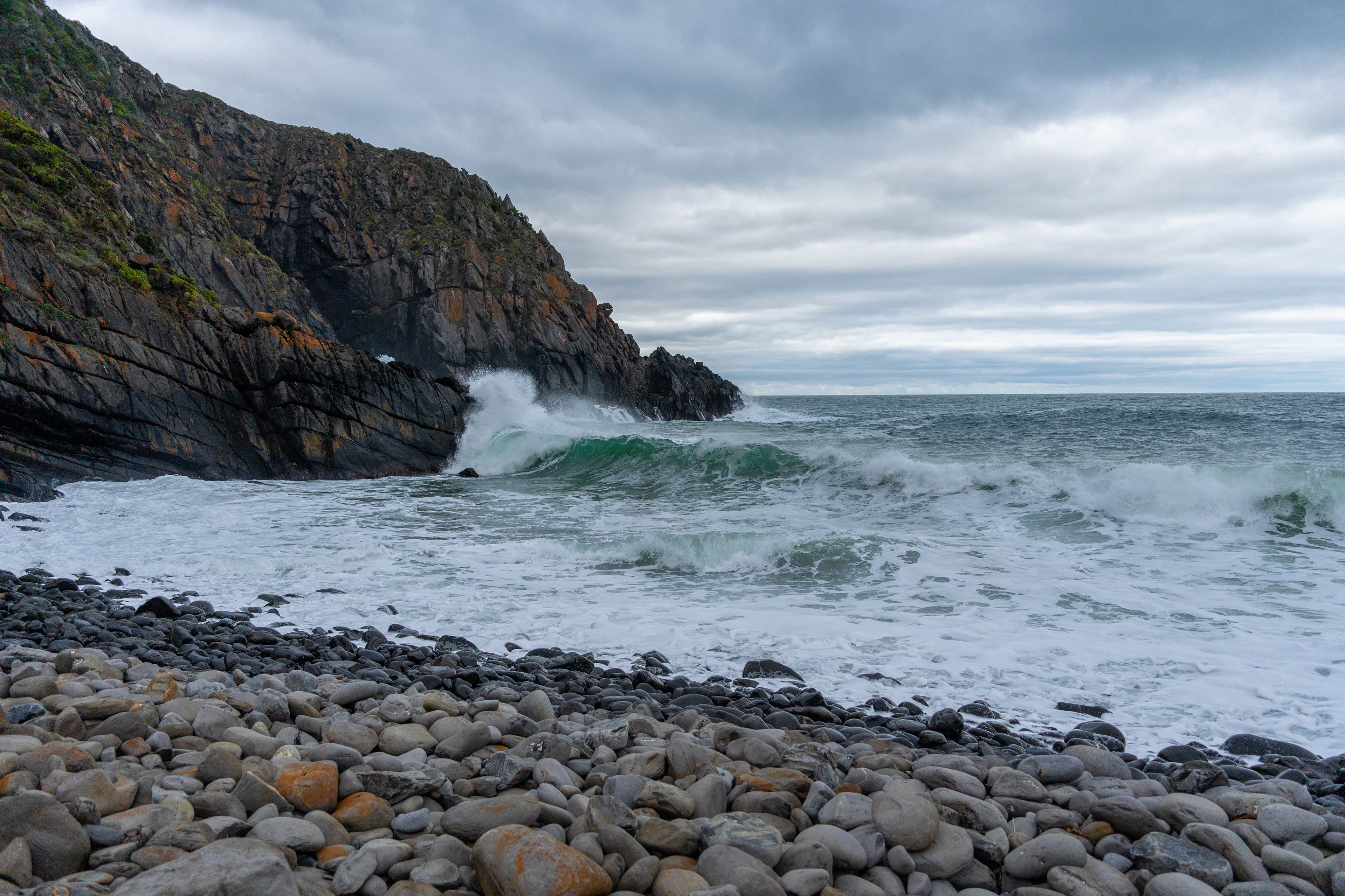 Sheer rock faces battered by waves at Deep Creek Cove